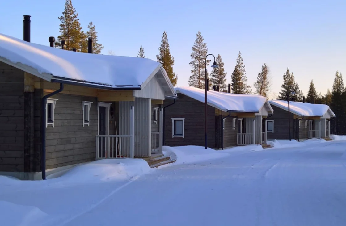 Chalets en bois du Valkea Lodge dans une forêt enneigée de Laponie finlandaise