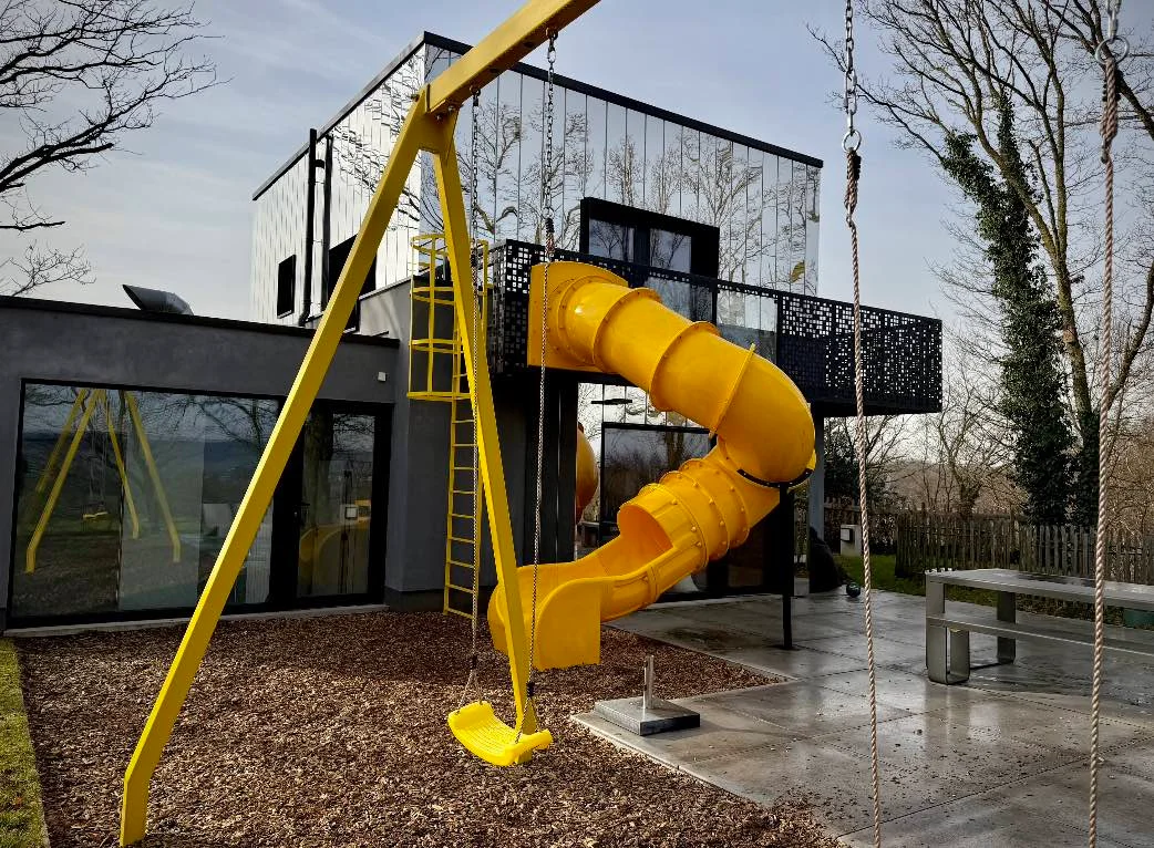 Ancien château d’eau Kindadom transformé en gîte familial avec toboggan jaune à Montzen