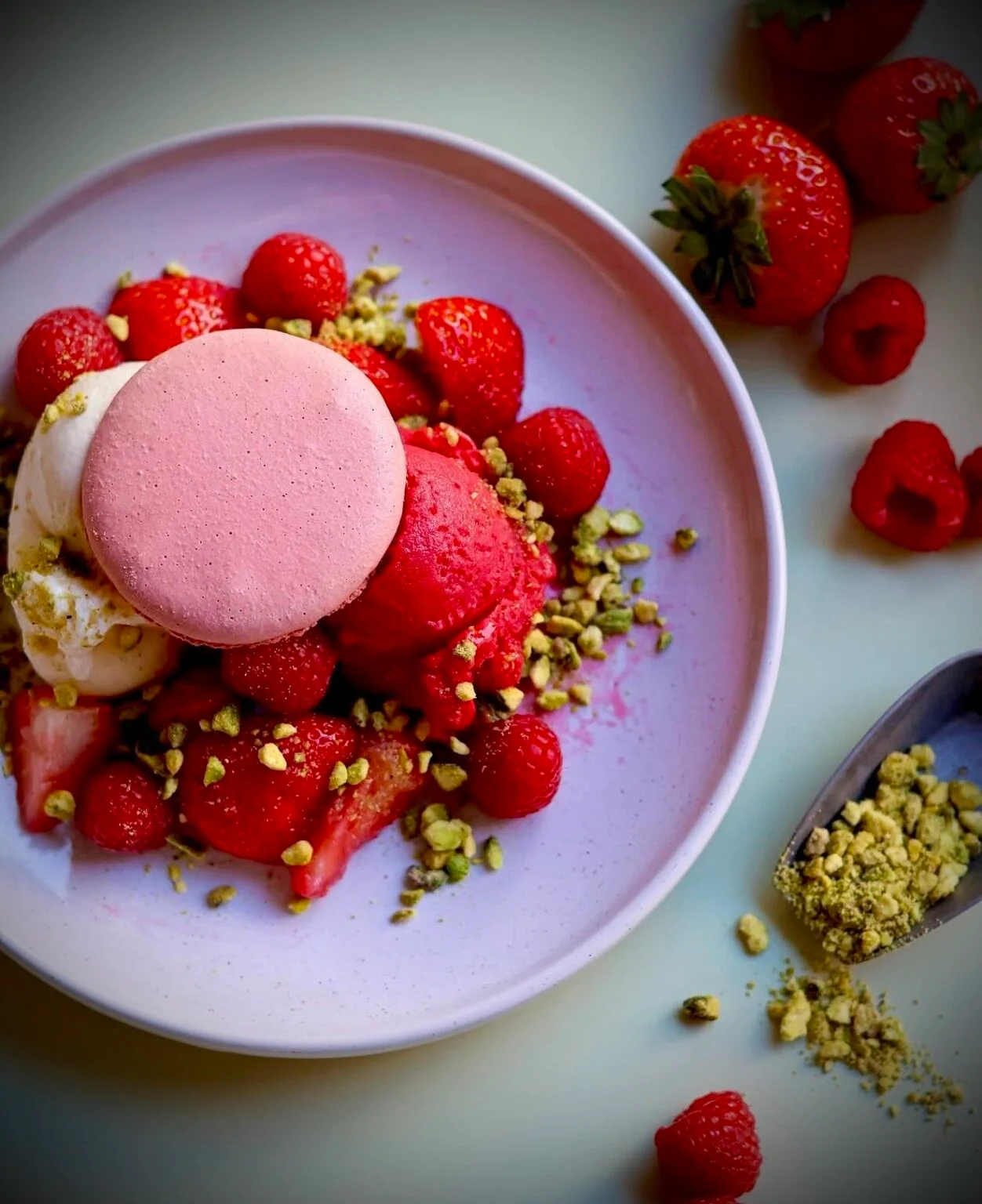 Dessert glacé aux fraises, framboises, pistaches et macaron rose