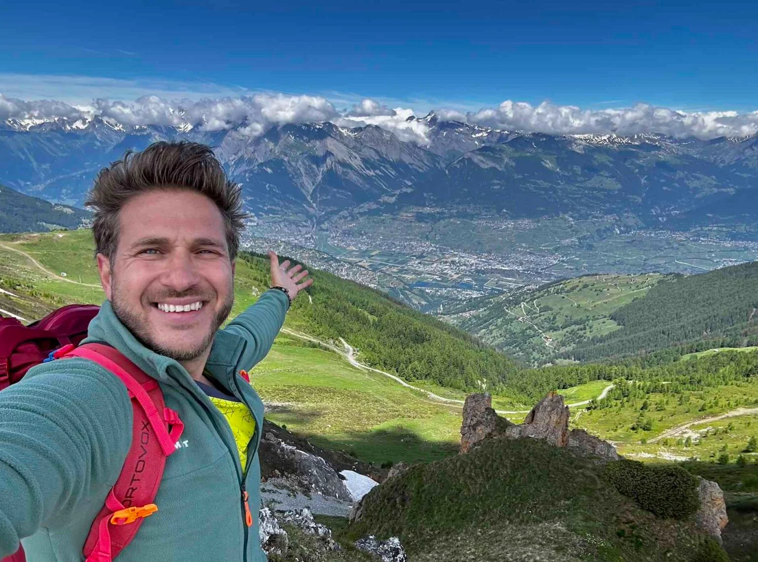 Randonneur contemplant la vallée et les Alpes depuis Nendaz