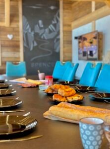 Le Chalet Spencer propose une salle à manger élégante et spacieuse, avec une grande table en bois et des chaises modernes. Cet espace lumineux, grâce à ses larges baies vitrées, permet de profiter d’une vue imprenable sur les montagnes pendant les repas. La cuisine entièrement équipée avec des appareils haut de gamme ravira les amateurs de gastronomie.